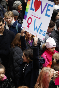 A woman holds a sign that reads 