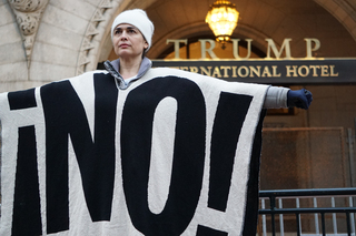 A woman stands in front of Trump International Hotel in Washington D.C.