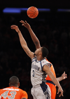 Georgetown's Mikael Hopkins (#3) and Syracuse's Rakeem Christmas fight for the ball at tipoff.