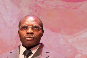 Cyprien Mihigo, a Congolese refugee and Syracuse University alumnus, sits on stage looking out into the audience during the rehearsal for Cry for Peace. Mihigo is a dramaturg and cultural consultant for Cry for Peace, opening at the Syracuse Stage on Friday, Sept. 14. 