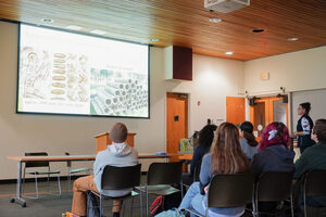 Students watch as Jennifer Bittner delivers a presentation on on-campus beekeeping at Syracuse University's Hall of Languages. The discussion mainly centered on the environmental challenges bees face.
