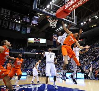 Syracuse point guard Michael Carter Williams gets bumped on a layup attempt as his teammates look on.