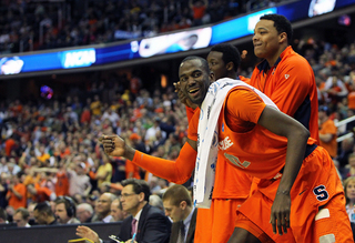 Baye Moussa-Keita #12 of the Syracuse Orange celebrates with teamates on the bench late in the game.