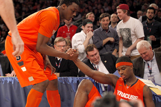 Missing the rebound, C.J. Fair flies off the court, falling onto spectators. Jeremy Grant lifts Fair off the ground.