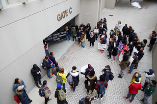 Student demonstrators gather at Gate C of the Carrier Dome, repeating chants such as 