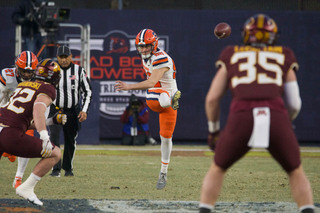 Syracuse's Brady Denaburg kicks the ball deep down the field toward the end zone where Minnesota returners await to receive the kick. 